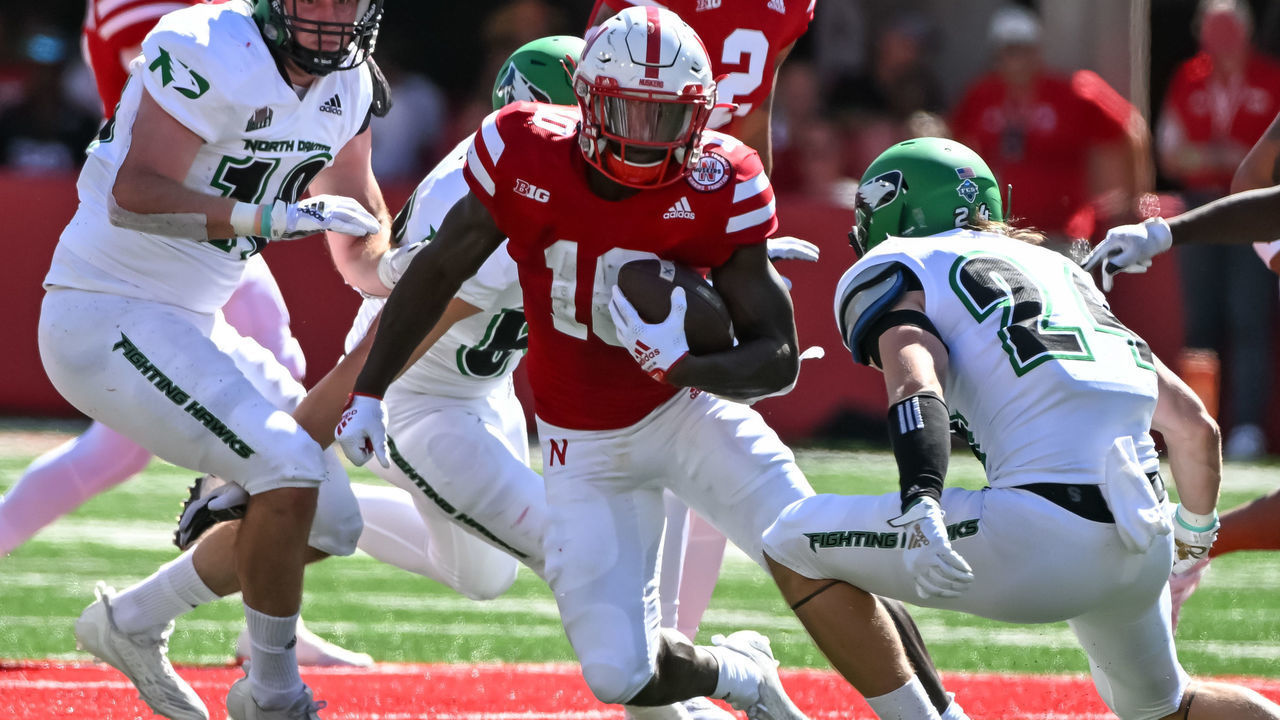 LINCOLN, NE - SEPTEMBER 3: Running back Anthony Grant #10 of the Nebraska Cornhuskers runs from defensive back Kadon Kauppinen #24 of the North Dakota Fighting Hawks in the first quarter at Memorial Stadium on September 3, 2022 in Lincoln, Nebraska.