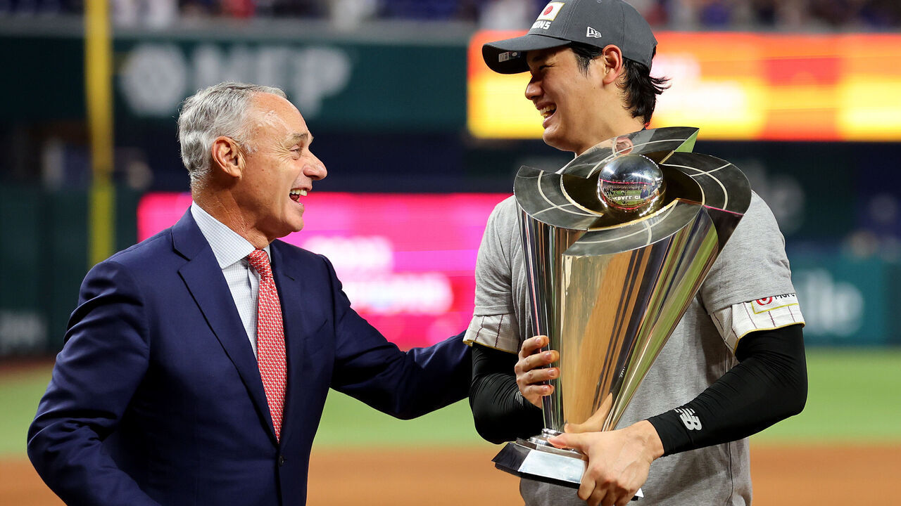 MIAMI, FLORIDA - MARCH 21: Shohei Ohtani (R) #16 of Team Japan is awarded the trophy by Commissioner of Baseball Rob Manfred (L) after defeating Team USA in the World Baseball Classic Championship at loanDepot park on March 21, 2023 in Miami, Florida.
