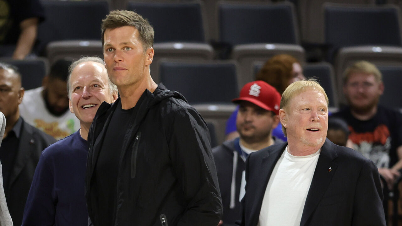 LAS VEGAS, NEVADA - MAY 31: (L-R) Sportscaster Jim Gray, Tampa Bay Buccaneers quarterback Tom Brady and Las Vegas Raiders owner and managing general partner and Las Vegas Aces owner Mark Davis watch players warm up during halftime of a game between the Connecticut Sun and the Aces at Michelob ULTRA Arena on May 31, 2022 in Las Vegas, Nevada. The Aces defeated the Sun 89-81.