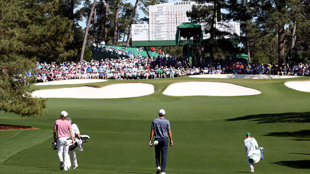 AUGUSTA, GEORGIA - APRIL 10: The group of Cameron Smith of Australia and Scottie Scheffler walks across the seventh hole during the final round of the Masters at Augusta National Golf Club on April 10, 2022 in Augusta, Georgia.