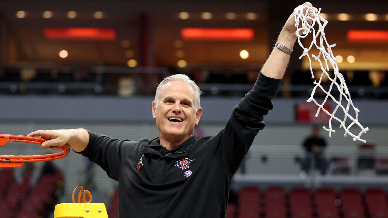 LOUISVILLE, KENTUCKY - MARCH 26: Head coach Brian Dutcher of the San Diego State Aztecs celebrates by cutting down the net after defeating the Creighton Bluejays in the Elite Eight round of the NCAA Men's Basketball Tournament at KFC YUM! Center on March 26, 2023 in Louisville, Kentucky.