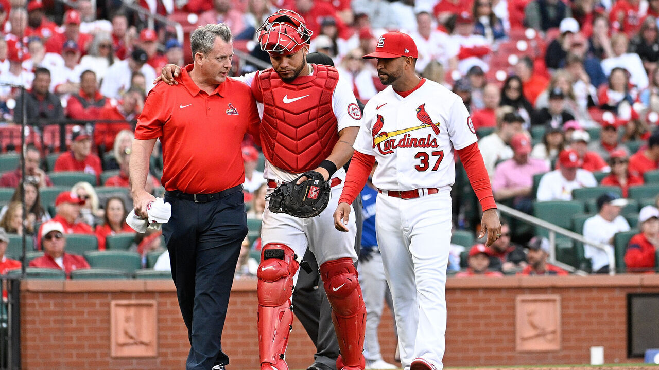 ST LOUIS, MO - MARCH 30: Willson Contreras #40 is helped off the field by Oliver Marmol #37 of the St. Louis Cardinals and training staff after sustaining an injury against the Toronto Blue Jays in the eighth inning on Opening Day at Busch Stadium on March 30, 2023 in St Louis, Missouri.