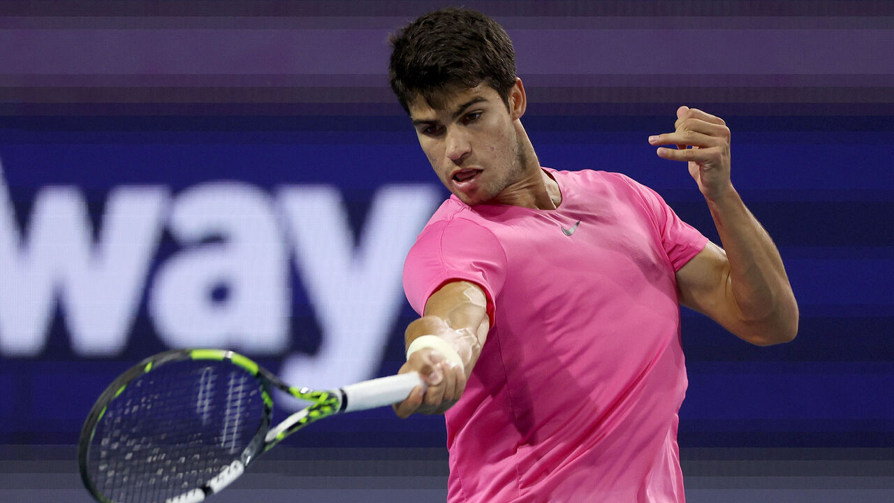 MIAMI GARDENS, FLORIDA - MARCH 30: Carlos Alcaraz of Spain returns a shot to Taylor Fritz of the United States during the quarterfinals of the Miami Open at Hard Rock Stadium on March 30, 2023 in Miami Gardens, Florida.