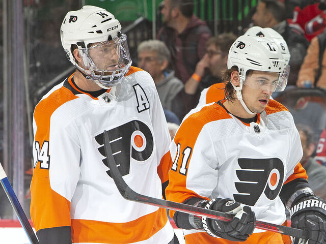 NEWARK, NJ - DECEMBER 08: Sean Couturier #14 of the Philadelphia Flyers talks with Travis Konecny #11 during the first period against the New Jersey Devils at the Prudential Center on December 8, 2021 in Newark, New Jersey.