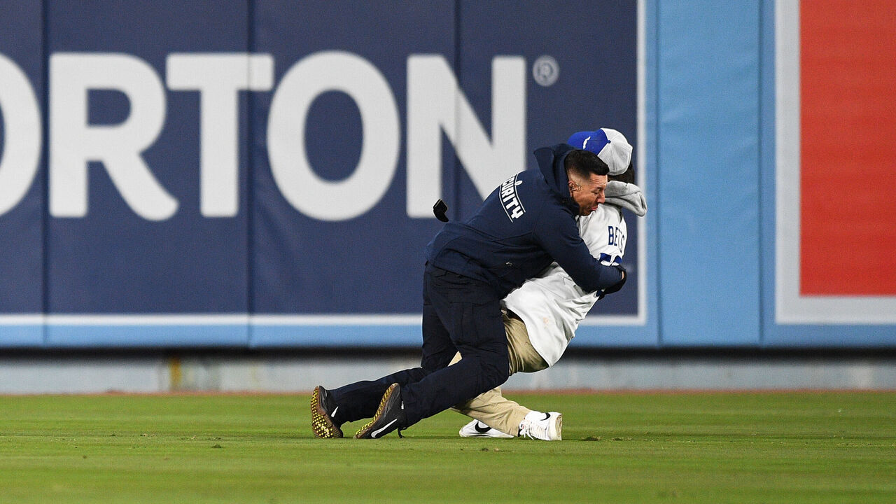 LOS ANGELES, CA - MARCH 30: A Dodger fan is tackled by security as he tries to propose to his girlfriend in the stands during the MLB game between the Arizona Diamondbacks and the Los Angeles Dodgers on March 30, 2022 at Dodger Stadium in Los Angeles, CA.