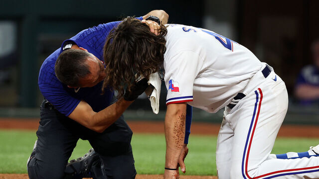 ARLINGTON, TEXAS - APRIL 03: Matt Lucero, athletic trainer for the Texas Rangers, attends to Josh Smith #47 after he was hit in the face by a pitch in the third inning against the Baltimore Orioles at Globe Life Field on April 03, 2023 in Arlington, Texas.