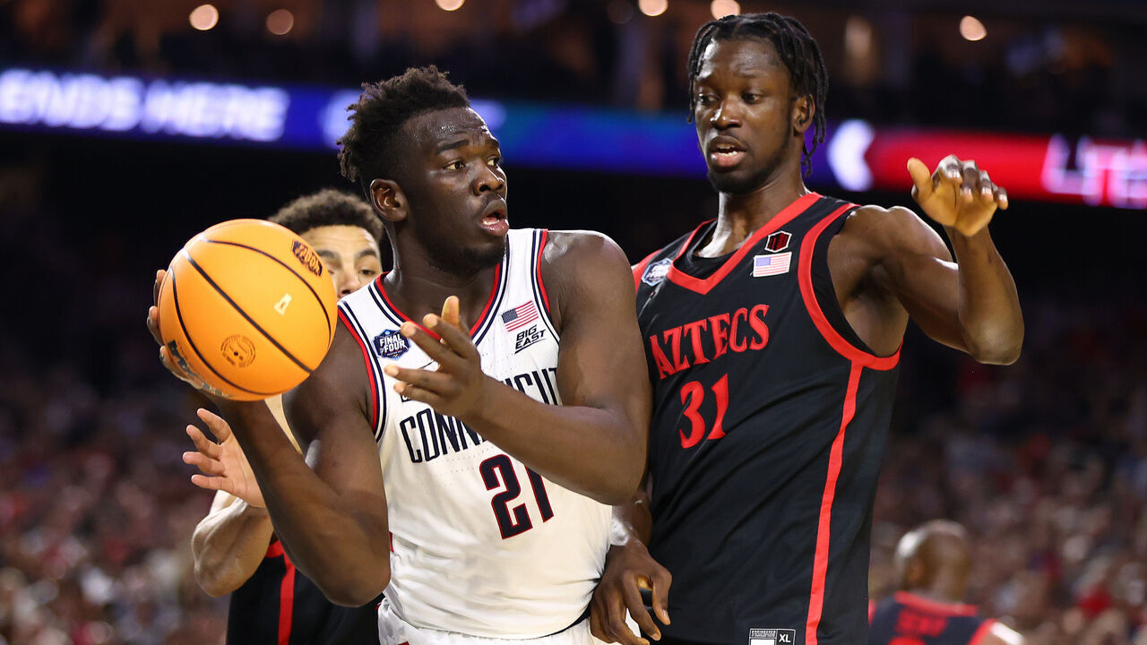 HOUSTON, TEXAS - APRIL 03: Adama Sanogo #21 of the Connecticut Huskies passes the ball against Nathan Mensah #31 of the San Diego State Aztecs during the first half in the NCAA Men's Basketball Tournament National Championship game at NRG Stadium on April 03, 2023 in Houston, Texas.
