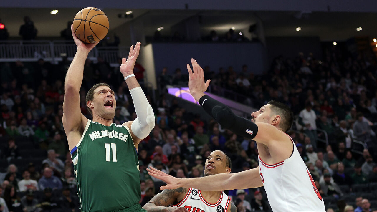 MILWAUKEE, WISCONSIN - APRIL 05: Brook Lopez #11 of the Milwaukee Bucks shoots over Nikola Vucevic #9 of the Chicago Bulls during the second half of a game at Fiserv Forum on April 05, 2023 in Milwaukee, Wisconsin.