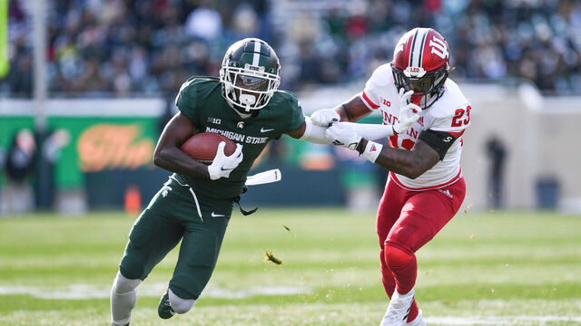 EAST LANSING, MI - NOVEMBER 19: Michigan State Spartans wide receiver Jayden Reed (1) fends off Indiana Hoosiers cornerback Jaylin Williams (23) during a college football game between the Michigan State Spartans and Indiana Hoosiers on November 19, 2022 at Spartan Stadium in East Lansing, MI