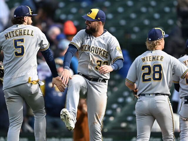 CHICAGO, ILLINOIS - APRIL 02: Garrett Mitchell #5 and Jesse Winker #33 of the Milwaukee Brewers celebrate against the Chicago Cubs at Wrigley Field on April 02, 2023 in Chicago, Illinois.