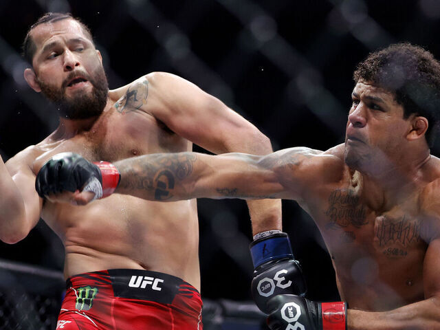 MIAMI, FLORIDA - APRIL 08: Gilbert Burns (R) of Brazil punches Jorge Masvidal in their welterweight bout during UFC 287 at Kaseya Center on April 08, 2023 in Miami, Florida.