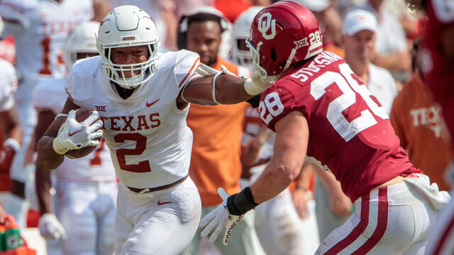 DALLAS, TX - OCTOBER 08: Texas Longhorns running back Roschon Johnson (2) stuff arms Oklahoma Sooners linebacker Danny Stutsman (28) during the second half on October 8th 2022 at the Cotton Bowl Stadium in Dallas Texas.