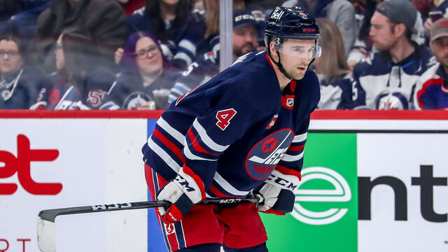 WINNIPEG, CANADA - MARCH 31: Neal Pionk #4 of the Winnipeg Jets looks on during a first period stoppage in play against the Detroit Red Wings at the Canada Life Centre on March 31, 2023 in Winnipeg, Manitoba, Canada. The Jets defeated the Wings 6-2.