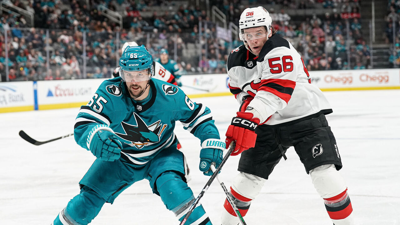 SAN JOSE, CA - JANUARY 16: Erik Karlsson #65 of the San Jose Sharks skates after the puck against Erik Haula #56 of the New Jersey Devils at SAP Center on January 16, 2023 in San Jose, California.