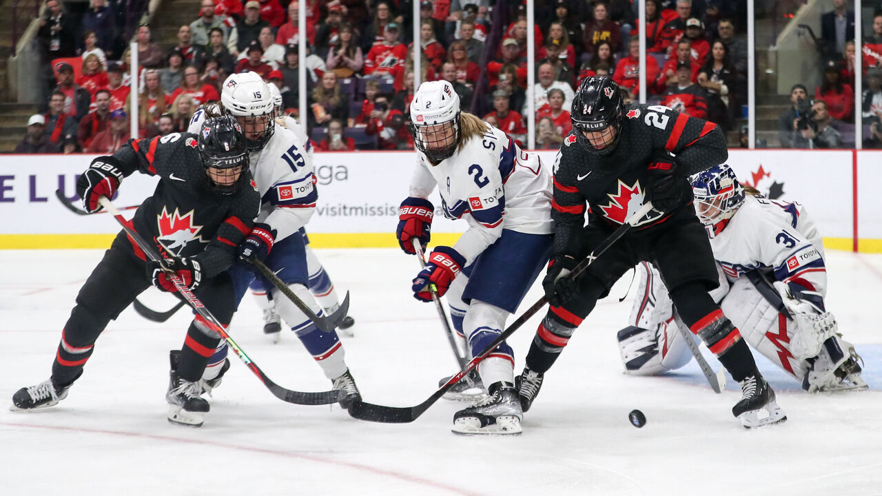 BRAMPTON, ONTARIO - APRIL 10: Forward Natalie Spooner #24 of Canada battles for a loose puck against defender Lee Stecklein #2 of USA during the 2023 IIHF Women's World Championship at CAA Centre on April 10, 2023 in Brampton, Ontario.