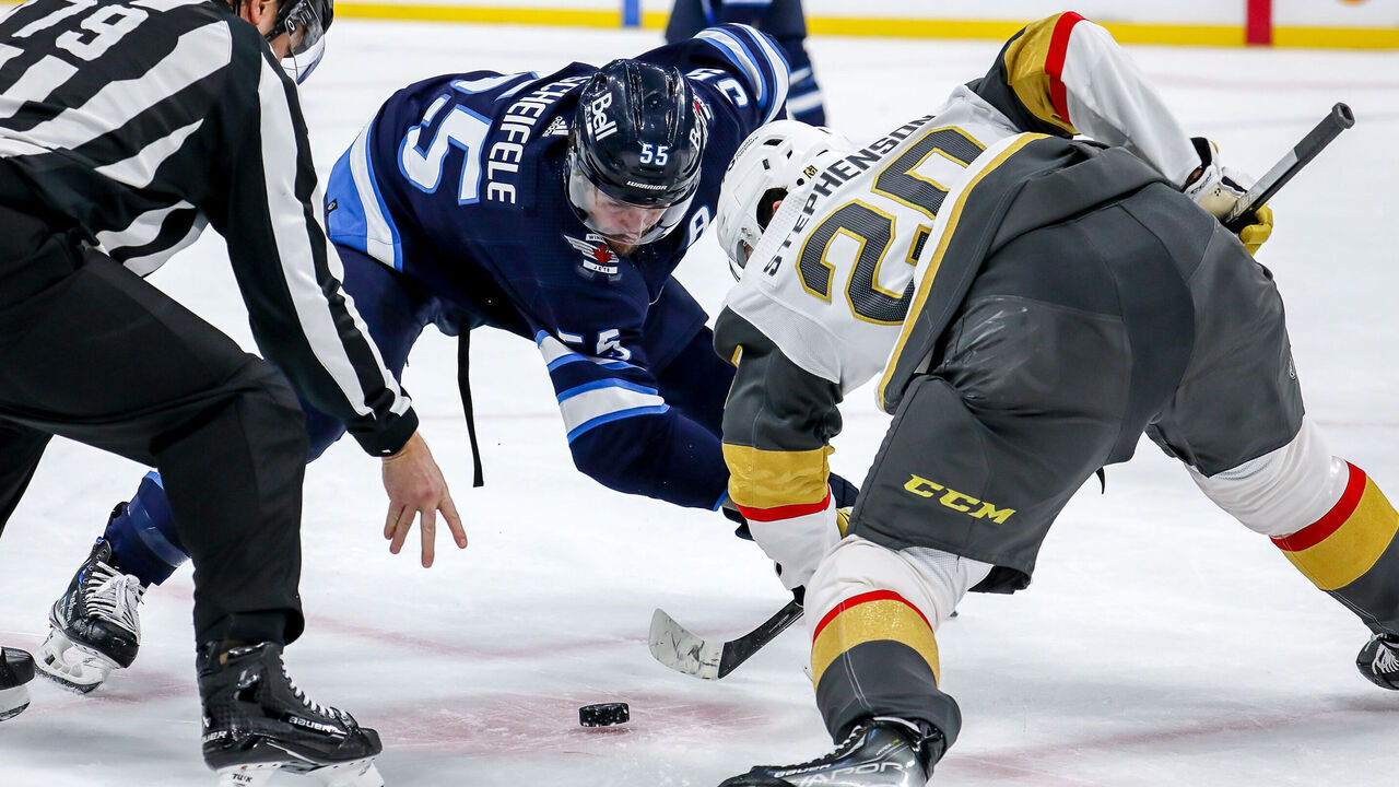 WINNIPEG, CANADA - DECEMBER 13: Mark Scheifele #55 of the Winnipeg Jets takes a second period face-off against Chandler Stephenson #20 of the Vegas Golden Knights at the Canada Life Centre on December 13, 2022 in Winnipeg, Manitoba, Canada.