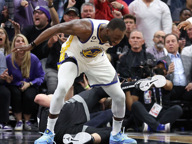 SACRAMENTO, CALIFORNIA - APRIL 17: Draymond Green #23 of the Golden State Warriors steps over Domantas Sabonis #10 of the Sacramento Kings in the second half during Game Two of the Western Conference First Round Playoffs at Golden 1 Center on April 17, 2023 in Sacramento, California. Green was issued a flagrant foul 2 on the play, and ejected from the game.