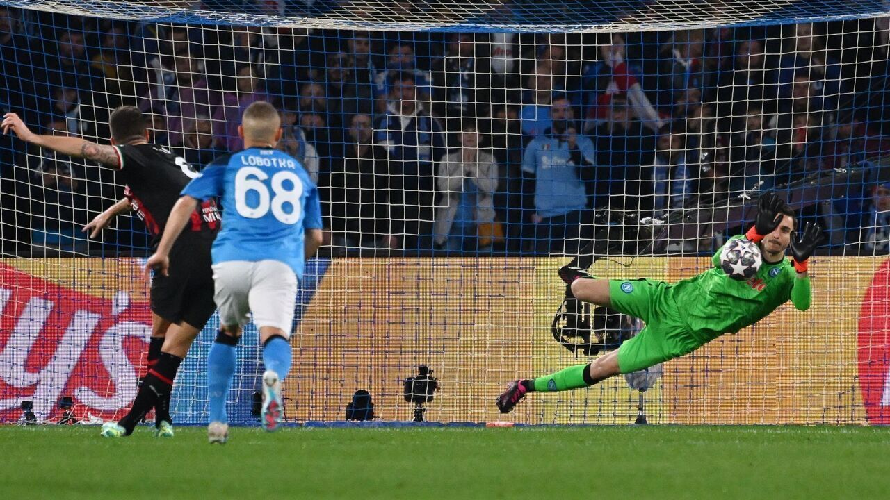 Napoli's Italian goalkeeper Alex Meret (R) defelects a penalty shot by AC Milan's French forward Olivier Giroud (L) during the UEFA Champions League quarter-finals second leg football match between SSC Napoli and AC Milan on April 18, 2023 at the Diego-Maradona stadium in Naples.