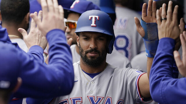 KANSAS CITY, MISSOURI - APRIL 19: Marcus Semien #2 of the Texas Rangers celebrates with teammates after scoring on a Adolis Garcia #53 sacrifice fly in the first inning against the Kansas City Royals at Kauffman Stadium on April 19, 2023 in Kansas City, Missouri.