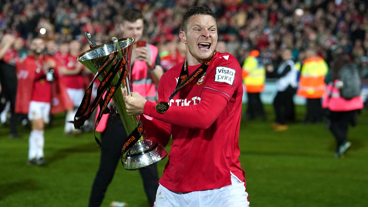 Wrexham's Paul Mullin celebrates with the trophy after promotion to the EFL following the Vanarama National League match at The Racecourse Ground, Wrexham. Picture date: Saturday April 22, 2023.