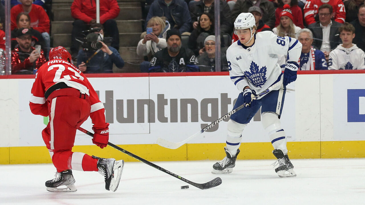 DETROIT, MI - JANUARY 12: Toronto Maple Leafs forward William Nylander (88) passes the puck past Detroit Red Wings forward Lucas Raymond (23) during the first period of an NHL regular season hockey game between the Toronto Maple Leafs and the Detroit Red Wings on January 12, 2023 at Little Caesars Arena in Detroit, Michigan.