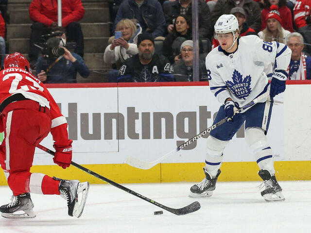 DETROIT, MI - JANUARY 12: Toronto Maple Leafs forward William Nylander (88) passes the puck past Detroit Red Wings forward Lucas Raymond (23) during the first period of an NHL regular season hockey game between the Toronto Maple Leafs and the Detroit Red Wings on January 12, 2023 at Little Caesars Arena in Detroit, Michigan.