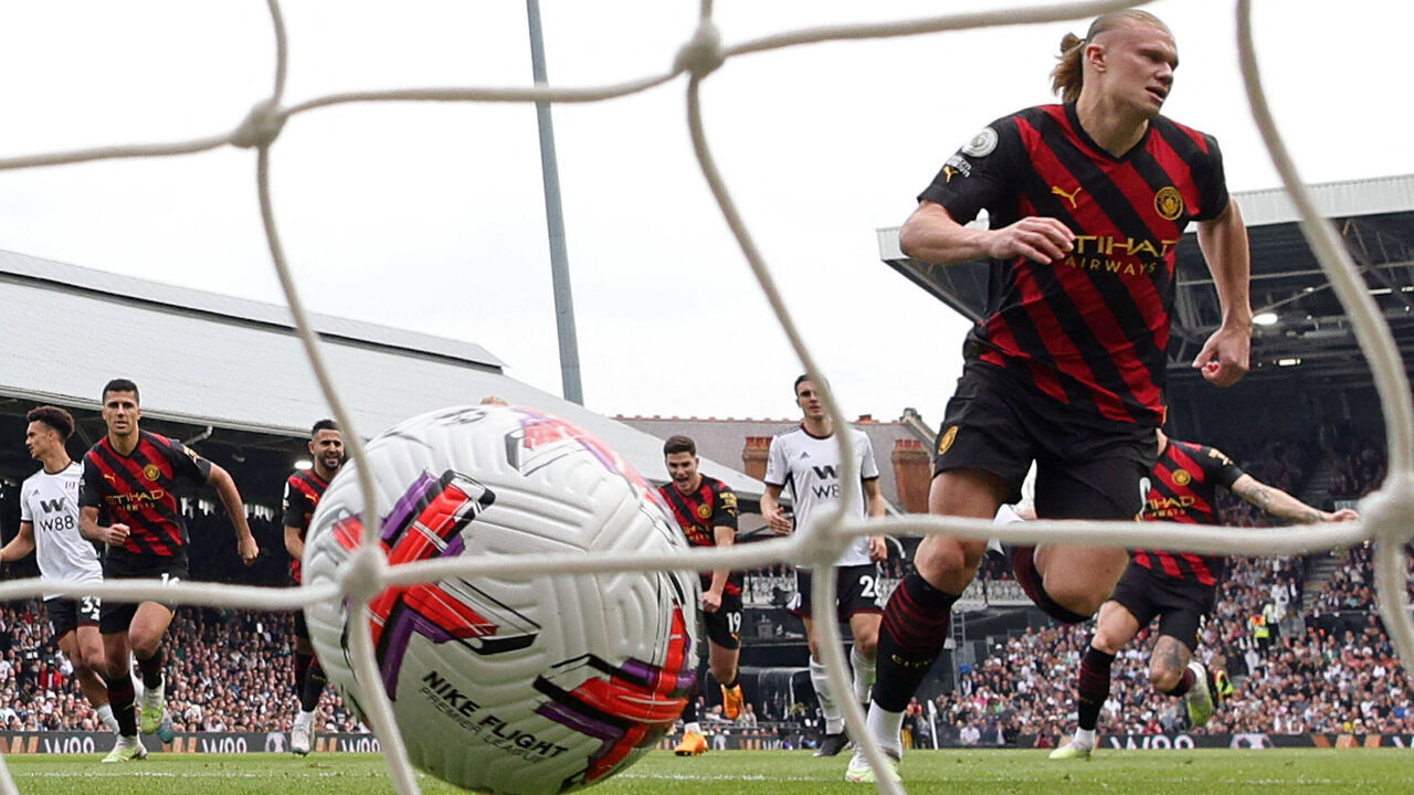 Manchester City's Norwegian striker Erling Haaland (R) celebrates after scoring the opening goal from the penalty spot during the English Premier League football match between Fulham and Manchester City at Craven Cottage in London on April 30, 2023.