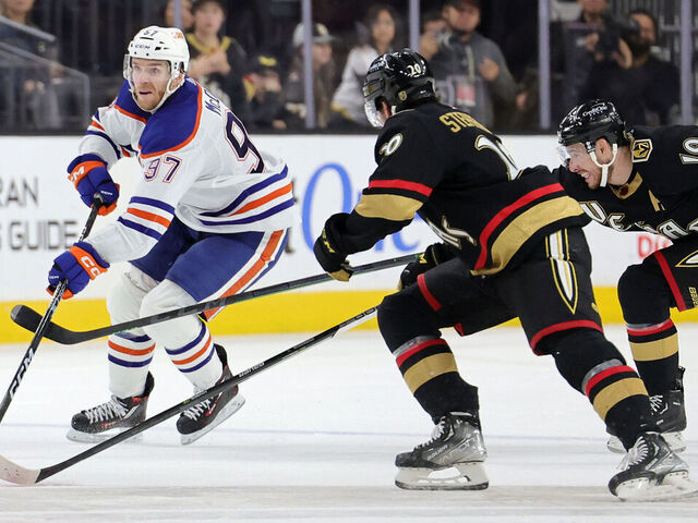 LAS VEGAS, NEVADA - JANUARY 14: Connor McDavid #97 of the Edmonton Oilers skates with the puck against Chandler Stephenson #20 and Reilly Smith #19 of the Vegas Golden Knights in the third period of their game at T-Mobile Arena on January 14, 2023 in Las Vegas, Nevada. The Oilers defeated the Golden Knights 4-3.