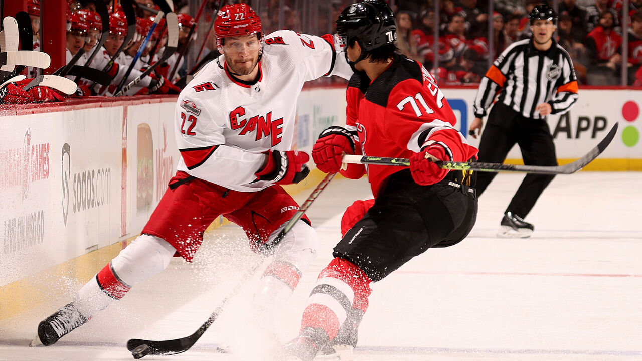 NEWARK, NEW JERSEY - MARCH 12: Brett Pesce #22 of the Carolina Hurricanes and Jonas Siegenthaler #71 of the New Jersey Devils collide during the first period at Prudential Center on March 12, 2023 in Newark, New Jersey.