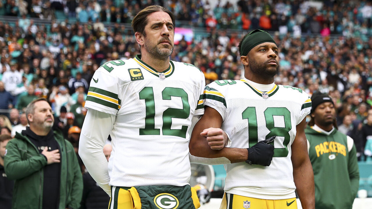 MIAMI GARDENS, FL - DECEMBER 25: Aaron Rodgers #12 of the Green Bay Packers links arms with Randall Cobb #18 on the sidelines during the national anthem before an NFL football game against the Miami Dolphins at Hard Rock Stadium on December 25, 2022 in Miami Gardens, Florida.