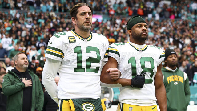 MIAMI GARDENS, FL - DECEMBER 25: Aaron Rodgers #12 of the Green Bay Packers links arms with Randall Cobb #18 on the sidelines during the national anthem before an NFL football game against the Miami Dolphins at Hard Rock Stadium on December 25, 2022 in Miami Gardens, Florida.