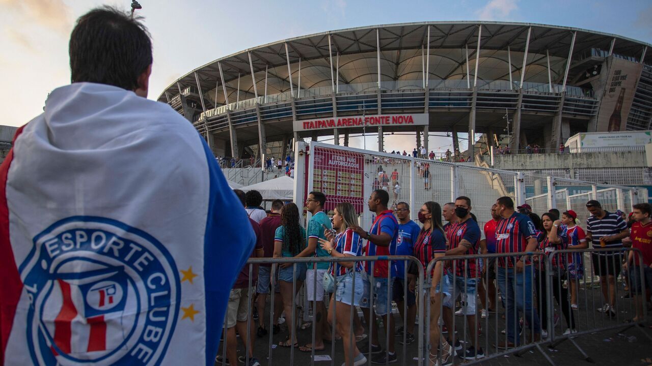 Supporters of Bahia are seen outside the Arena Fonte Nova stadium before the Brazil's Second Division Football Championship match between Bahia and Operario in Salvador, Bahia state, Brazil, on September 24, 2022. - EC Bahia football team, in northeastern Salvador, is a rare safe space for gay fans who often steer clear of football stadiums for fear of coming under attack. The Torcida LGBTricolor fan collective, founded in September 2019 with the support of EC Bahia (currently in the second division), has become known for its progressive attitude in recent years. The supporters count only 15 members, a far cry from other massive Brazilian fan groups. However, the fact that they can go to the stadium waving rainbow flags and wearing rainbow T-shirts is no small matter. In other Brazilian football stadiums, homosexual fans are forced to fly under the radar to avoid homophobic chants, insults, hostile looks, and even assaults.