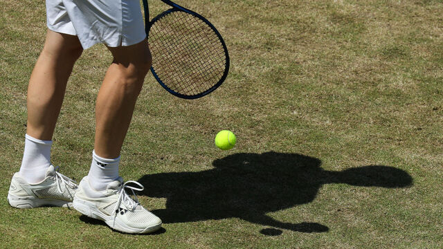 15 June 2021, North Rhine-Westphalia, Halle: Tennis: ATP Tour Singles, Men, 1st Round, Rodionov (Austria) - Kohlschreiber (Germany). The shadow of Yuri Rodionov can be seen on the grass. Photo: Friso Gentsch/dpa