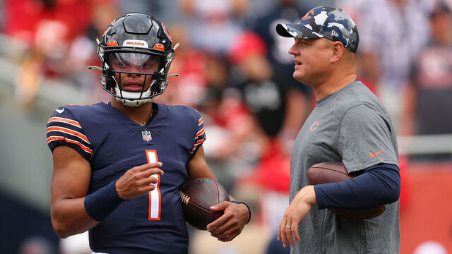 CHICAGO, ILLINOIS - AUGUST 13: Justin Fields #1 of the Chicago Bears talks with offensive coordinator Luke Getsy prior to a preseason game against the Kansas City Chiefs at Soldier Field on August 13, 2022 in Chicago, Illinois.