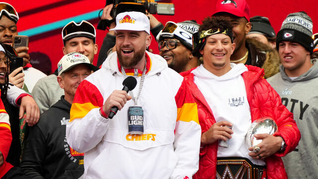 KANSAS CITY, MISSOURI - FEBRUARY 15: Travis Kelce #87 and Patrick Mahomes #15 of the Kansas City Chiefs celebrate on stage during the Kansas City Chiefs Super Bowl LVII victory parade on February 15, 2023 in Kansas City, Missouri.