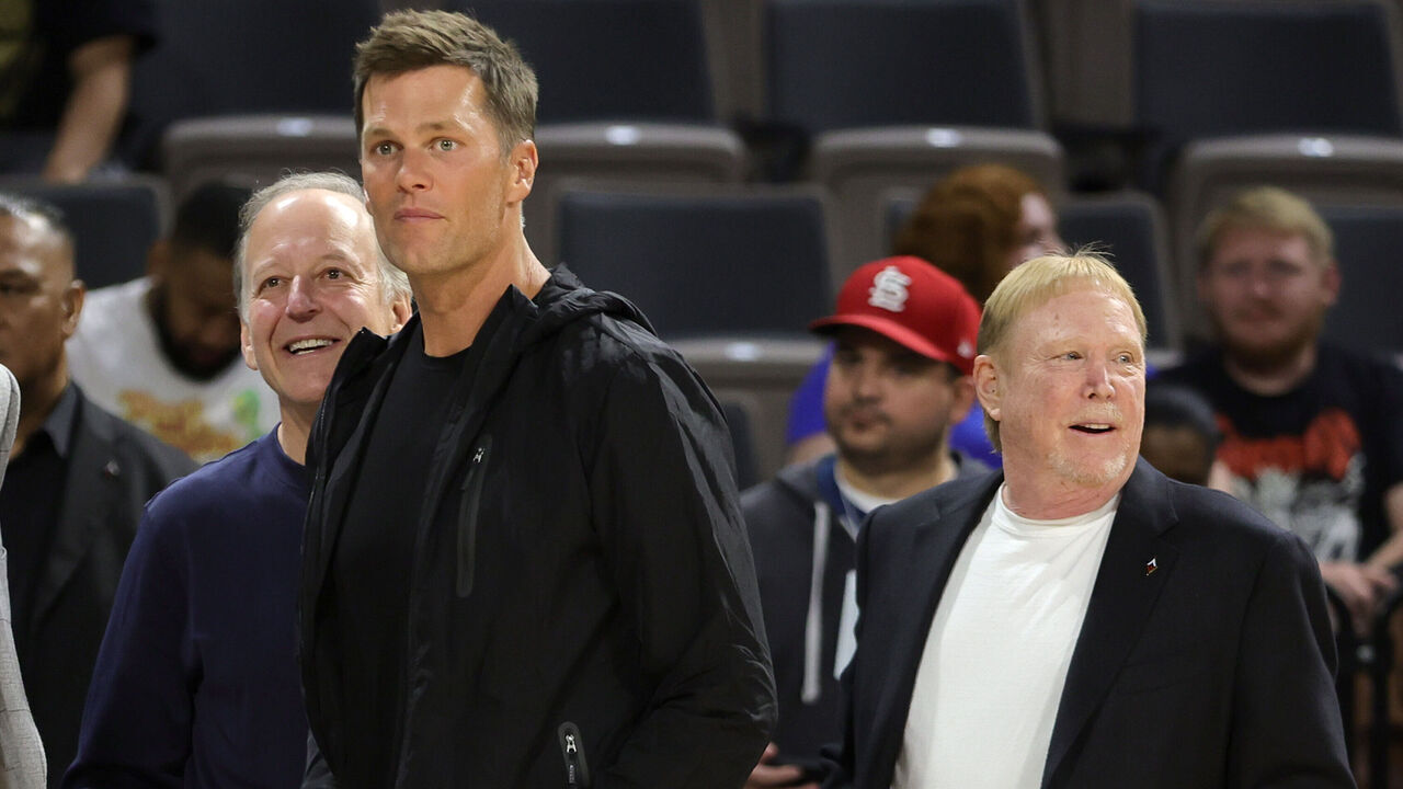 LAS VEGAS, NEVADA - MAY 31: (L-R) Sportscaster Jim Gray, Tampa Bay Buccaneers quarterback Tom Brady and Las Vegas Raiders owner and managing general partner and Las Vegas Aces owner Mark Davis watch players warm up during halftime of a game between the Connecticut Sun and the Aces at Michelob ULTRA Arena on May 31, 2022 in Las Vegas, Nevada. The Aces defeated the Sun 89-81.