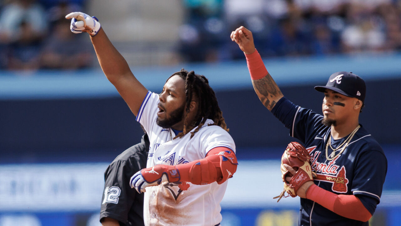TORONTO, ON - MAY 13: Vladimir Guerrero Jr. #27 of the Toronto Blue Jays reacts as he takes second base in front of Orlando Arcia #11 of the Atlanta Braves in the fourth inning at Rogers Centre on May 13, 2023 in Toronto, Canada.