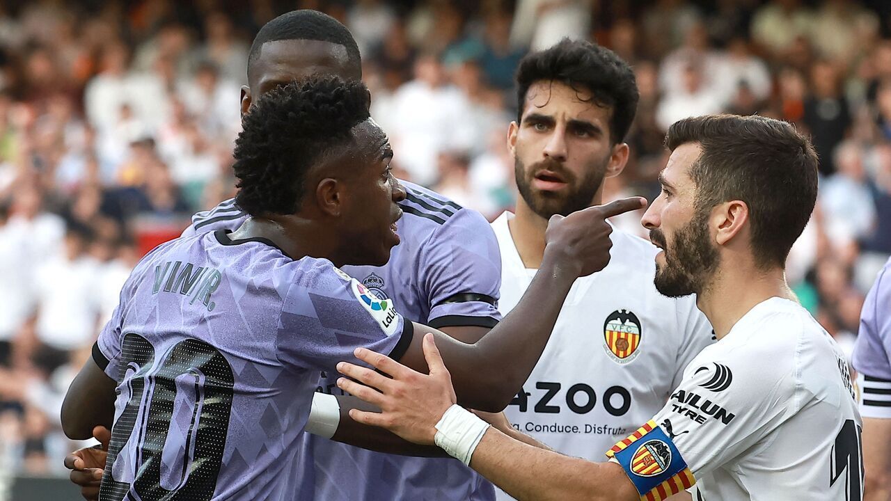 Valencia's Spanish defender Jose Gaya (R) gestures to Real Madrid's Brazilian forward Vinicius Junior pointing the stands after being insulted from the stands during the Spanish league football match between Valencia CF and Real Madrid CF at the Mestalla stadium in Valencia on May 21, 2023. Spanish prosecutors opened a probe on May 22, 2023 into racist chants aimed at Real Madrid's star forward Vinicius Junior during a match as the football federation president admitted the country had a "problem" with racism.