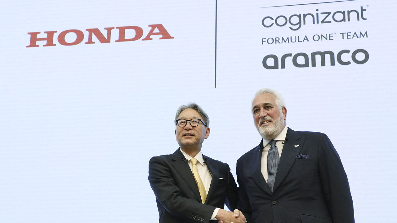 Honda Motor President Toshihiro Mibe (L) shakes hands with Aston Martin F1 executive chairman Lawrence Stroll during a press conference in Tokyo on May 24, 2023.