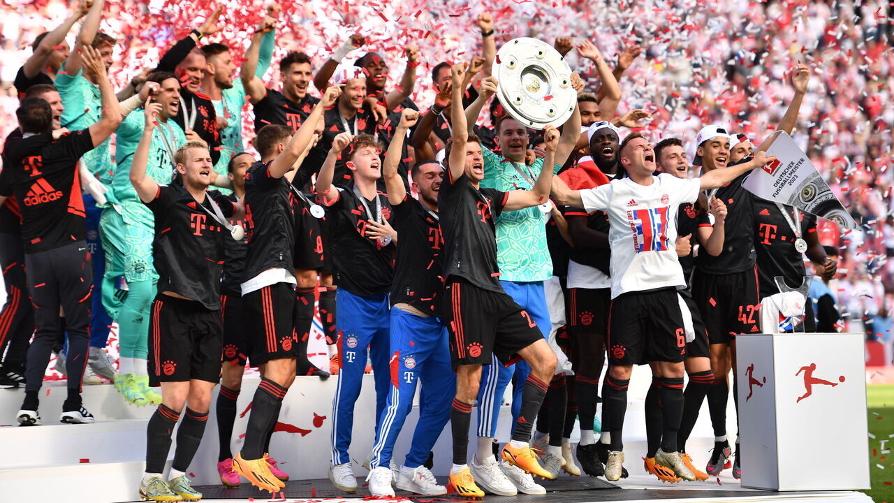 dpatop - 27 May 2023, North Rhine-Westphalia, Cologne: Soccer: Bundesliga, 1st FC Cologne - Bayern Munich, Matchday 34, RheinEnergieStadion. Bayern goalkeeper Manuel Neuer (center right) holds up the championship trophy while his teammates cheer after winning the 33rd German championship. IMPORTANT NOTE: In accordance with the requirements of the DFL Deutsche Fußball Liga and the DFB Deutscher Fußball-Bund, it is prohibited to use or have used photographs taken in the stadium and/or of the match in the form of sequence pictures and/or video-like photo series. Photo: Marius Becker/dpa