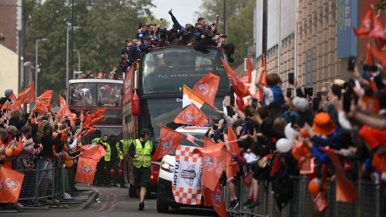 Luton Town football club players and staff parade through the streets of Luton with the Championship playoff trophy in Luton, north of London on May 29, 2023, as they celebrate their promotion to the English Premier League. Luton completed a fairytale journey to the Premier League after winning the Championship playoff final at Wembley on Saturday. Financial experts estimate promotion to world football's most watched league to be worth around £170 million ($210 million) for a club that have been through turmoil since they last played in the top flight 31 years ago.