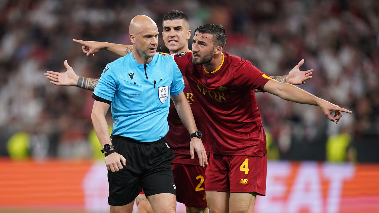 Referee Anthony Taylor is surrounded by Roma players during the UEFA Europa League Final at the Puskas Arena, Budapest. Picture date: Wednesday May 31, 2023.