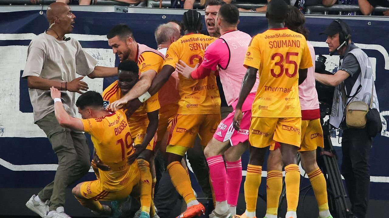 Rodez' French midfielder Lucas Buades (2nd-L) celebrates with teammates after scoring a goal as a spectator (C) scuffles with players after entering the pitch during the French L2 football match between FC Girondins de Bordeaux and Rodez AF at the Matmut Atlantique Stadium in Bordeaux, on June 2, 2023.