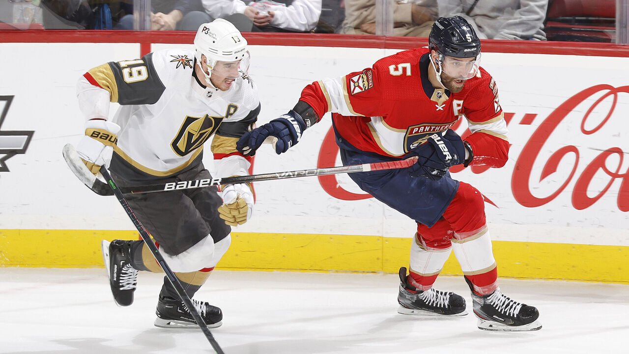 SUNRISE, FL - MARCH 7: Reilly Smith #19 of the Vegas Golden Knights and Aaron Ekblad #5 of the Florida Panthers chase a loose puck during second period action at the FLA Live Arena on March 7, 2023 in Sunrise, Florida.