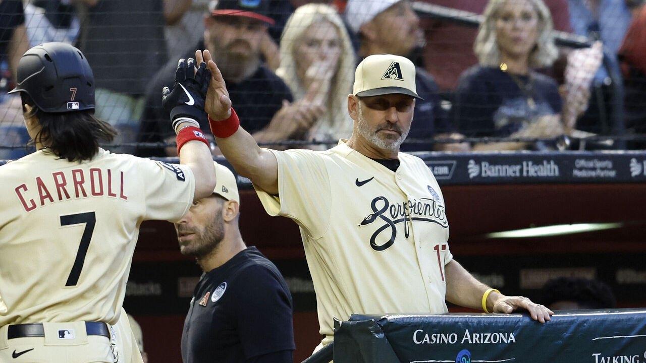 PHOENIX, ARIZONA - JUNE 02: Corbin Carroll #7 of the Arizona Diamondbacks high fives manager Torey Lovullo #17 after scoring a run against the Atlanta Braves during the third inning at Chase Field on June 02, 2023 in Phoenix, Arizona.