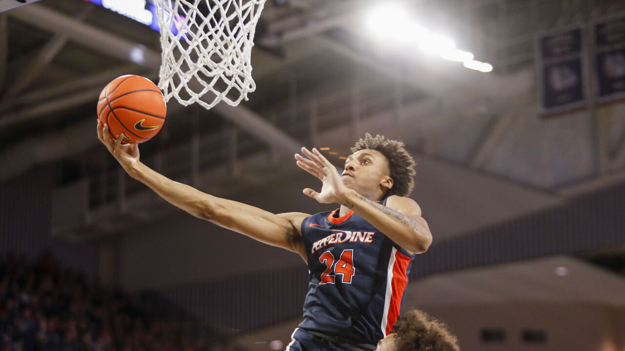 SPOKANE, WA - DECEMBER 31: Pepperdine Waves forward Maxwell Lewis (24) jumps and lays the ball in the net during the game between the Pepperdine Waves and the Gonzaga Bulldogs on December 31, 2022, at McCarthey Athletic Center in Spokane, WA.
