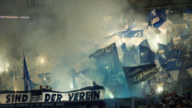 GELSENKIRCHEN, GERMANY - APRIL 14: Fans of Hertha BSC show their support with flares pyrotechnics and Flags during the Bundesliga match between FC Schalke 04 and Hertha BSC at Veltins-Arena on April 14, 2023 in Gelsenkirchen, Germany.