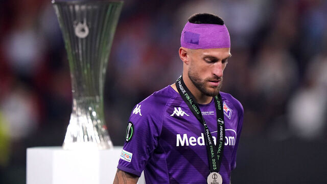Fiorentina's Cristiano Biraghi (right) looks dejected as he walks past the Europa Conference League Trophy following defeat in the UEFA Europa Conference League Final at the Fortuna Arena, Prague. Picture date: Wednesday June 7, 2023.