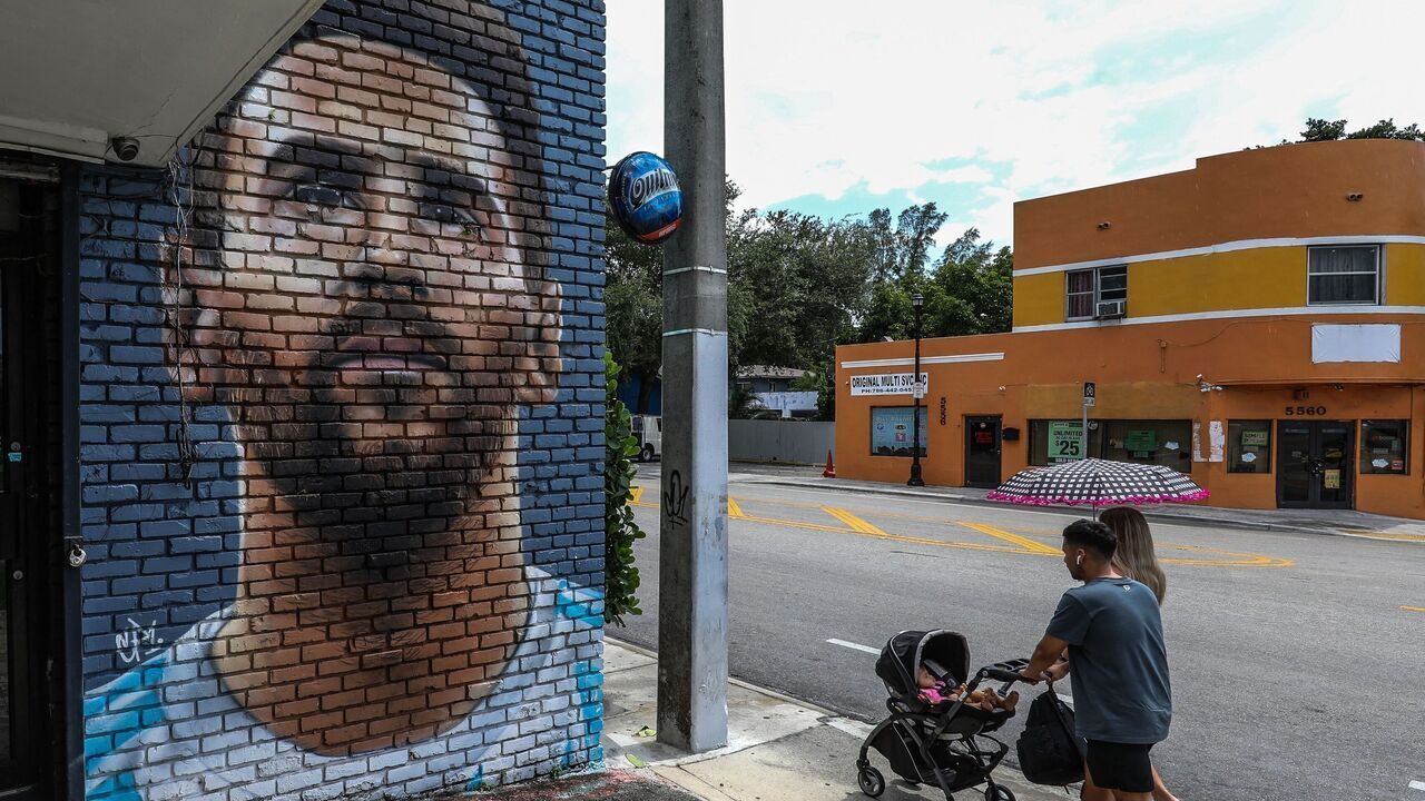People walk in front of a mural depicting Argentine football player Lionel Messi in Miami on June 7, 2023. Lionel Messi on Wednesday announced he will sign for Major League Soccer side Inter Miami, choosing the United States as his next destination over a Barcelona reunion or blockbuster deal to play in Saudi Arabia.