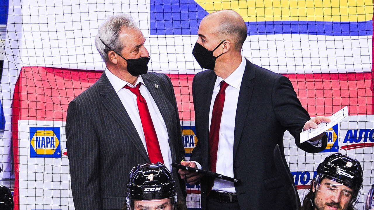 CALGARY, AB - MARCH 11: Head Coach Darryl Sutter and Assistant Coach Ryan Huska of the Calgary Flames confer during a break in play against the Montreal Canadiens during an NHL game at Scotiabank Saddledome on March 11, 2021 in Calgary, Alberta, Canada.